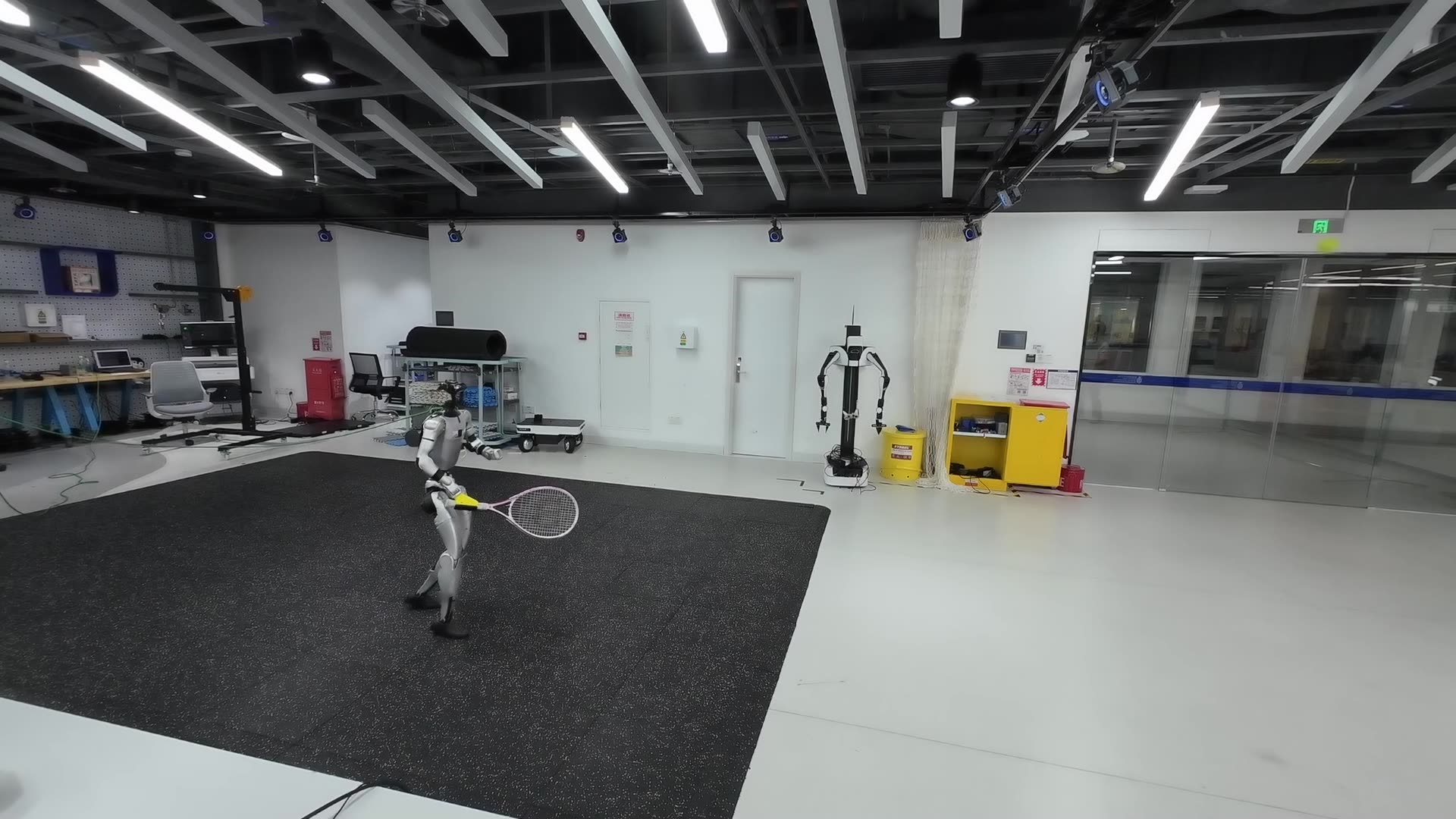 A Unitree G1 humanoid holding a tennis racket during a real-world rally